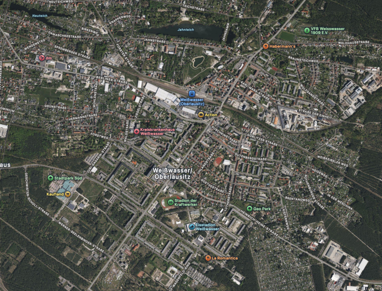 Luftaufnahme von Weißwasser mit Straßen, Gebäuden und grünen Flächen.