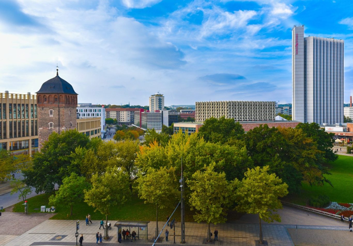 Detektei Chemnitz Stadtansicht mit Bäumen, Gebäuden und blauem Himmel.