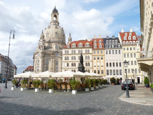 Dresdner Altmarkt mit historischen Gebäuden, Außenbewirtschaftung und Frauenkirche im Hintergrund.