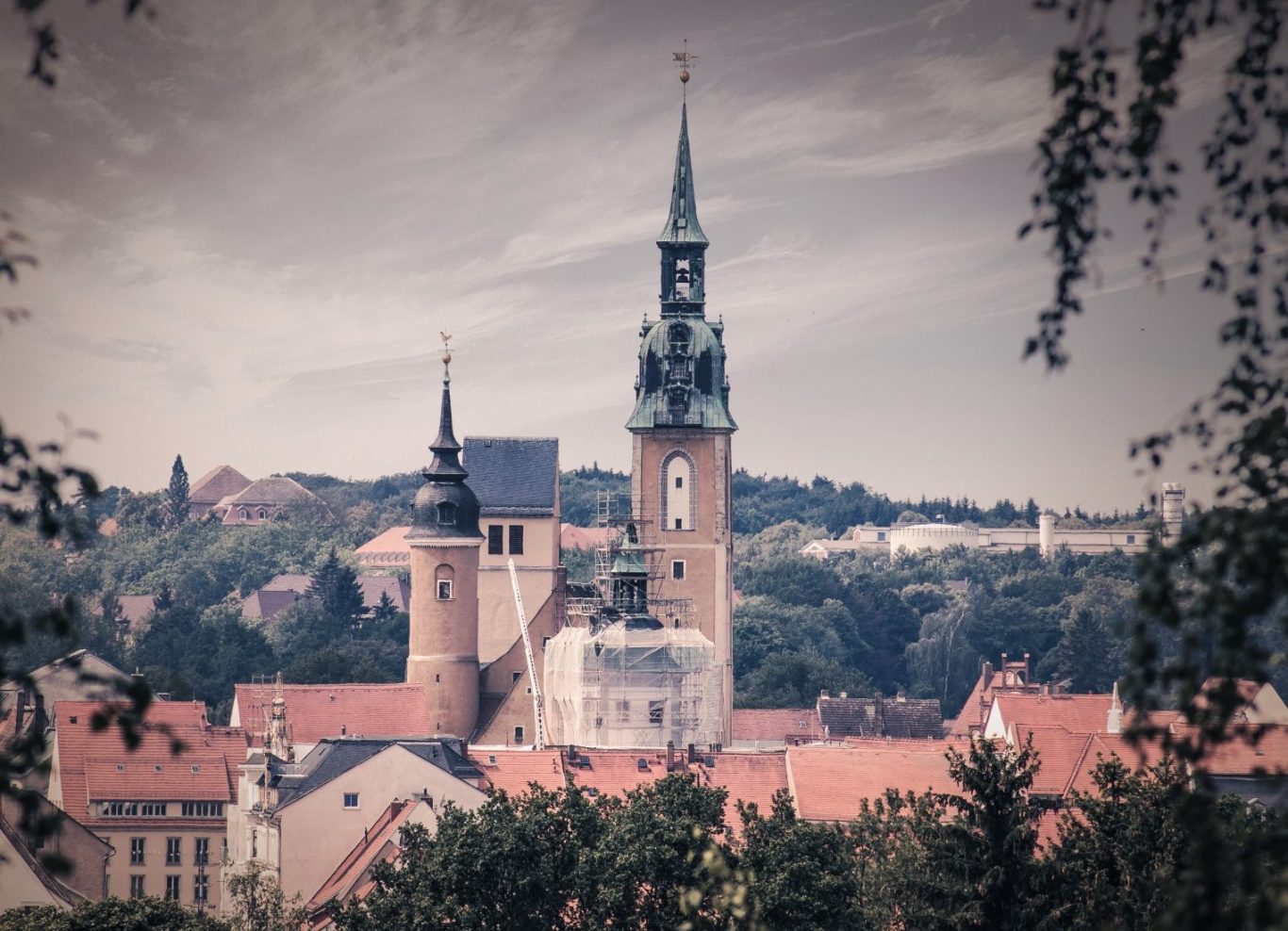 Aussicht auf eine Stadt mit Türmen und historischen Gebäuden im Hintergrund.