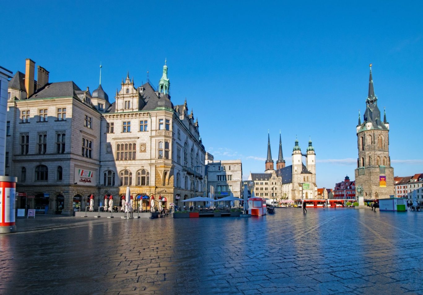 Blick auf den Marktplatz mit historischen Gebäuden und Türmen bei klarem Himmel.