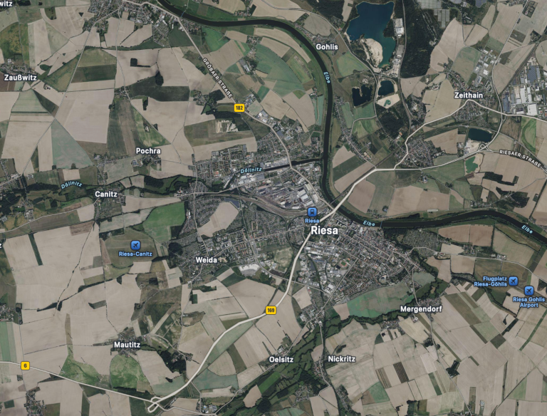 Luftaufnahme der Stadt Riesa umgeben von landwirtschaftlichen Flächen und Flüssen.