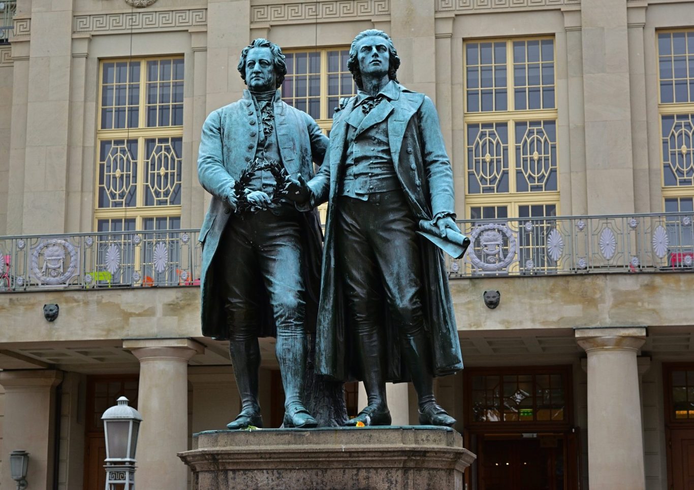 Statue von Goethe und Schiller vor einem historischen Gebäude.